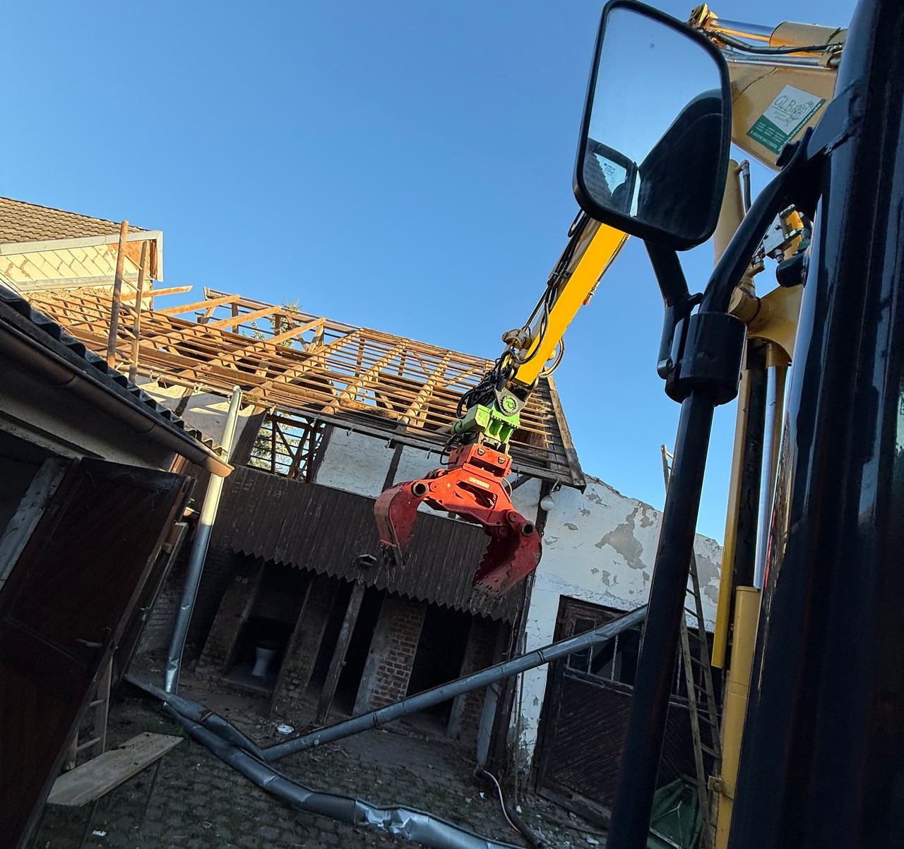 Bagger mit Greifer bei Abrissarbeiten an einem Gebäude
