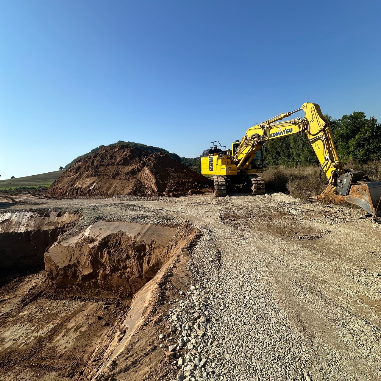 Baugrube mit Bagger und Erdmaterial