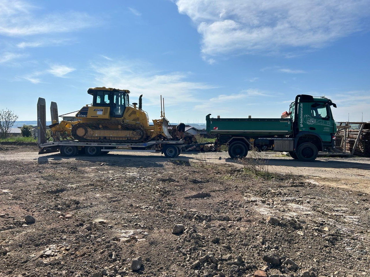 Baumaschine auf Tieflader mit Lkw auf einer Baustelle