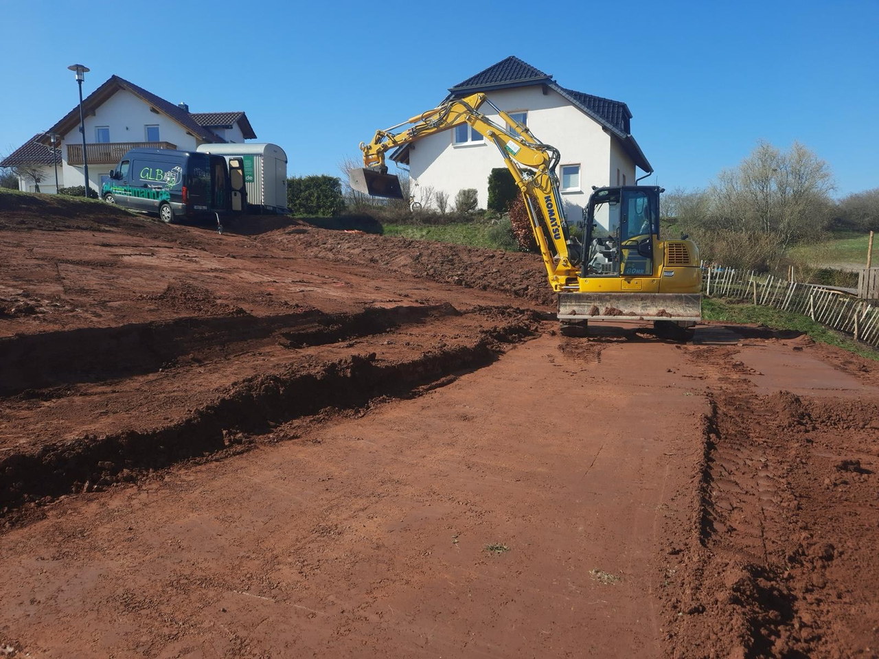 Bagger bei Erdarbeiten für Garten- und Landschaftsbau an einem Wohnhaus