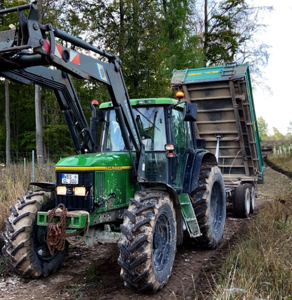 Traktor mit Anhänger beim Materialtransport im Gelände
